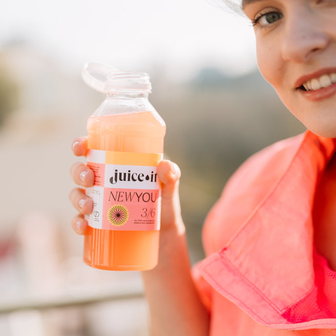 Femeie ținând în mână un suc Juiceit New You, perfect pentru programul de detoxifiere și un stil de viață sănătos.